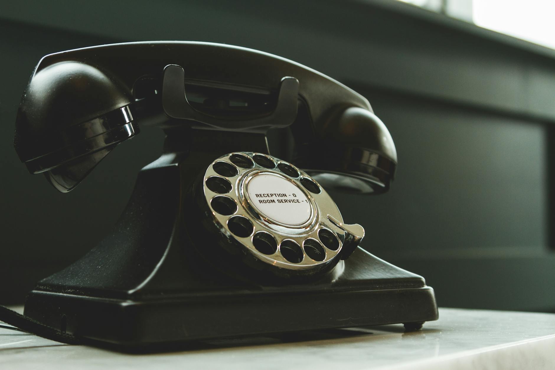 black rotary telephone on white surface